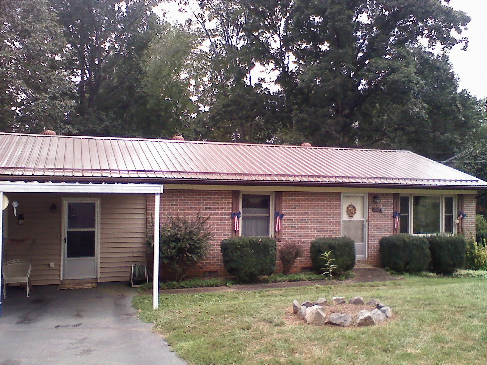 Bronze metal roof and carport on a brick ranch home — Roof Repair work by our crew in Slater